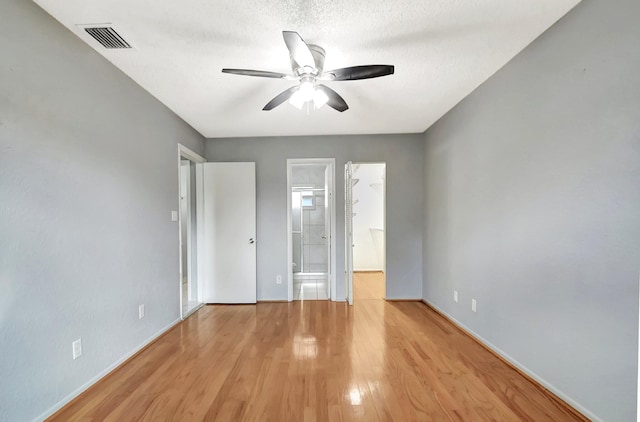 unfurnished room with a textured ceiling, ceiling fan, and light wood-type flooring