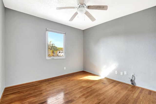 unfurnished room with a textured ceiling, wood-type flooring, and ceiling fan