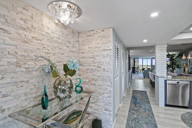 corridor featuring an inviting chandelier and decorative columns