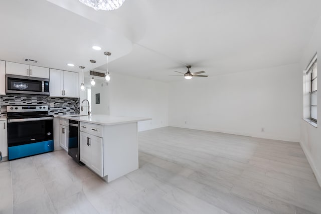 kitchen with sink, white cabinetry, pendant lighting, stainless steel appliances, and backsplash