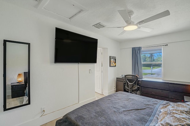 bedroom with ceiling fan and a textured ceiling