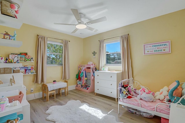 bedroom with multiple windows, ceiling fan, and light wood-type flooring