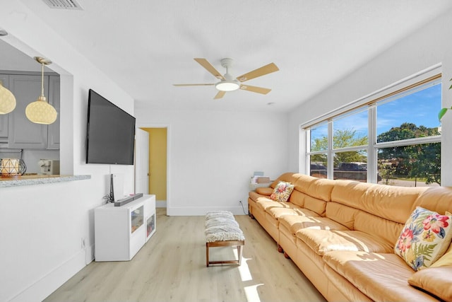 living room with light hardwood / wood-style floors and ceiling fan