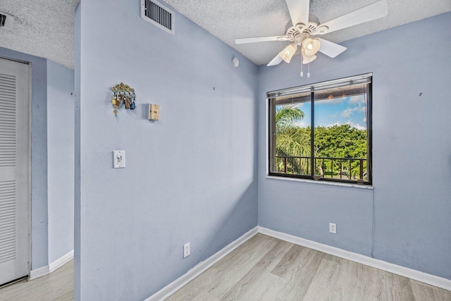 unfurnished room featuring ceiling fan, light hardwood / wood-style flooring, and a textured ceiling