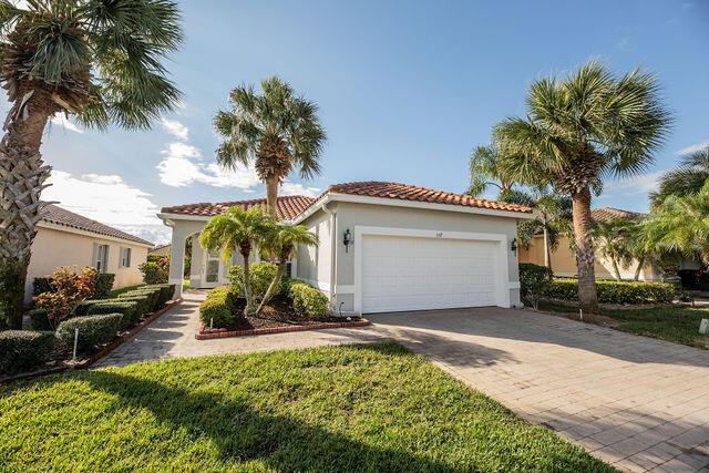 mediterranean / spanish-style home featuring a garage and a front yard