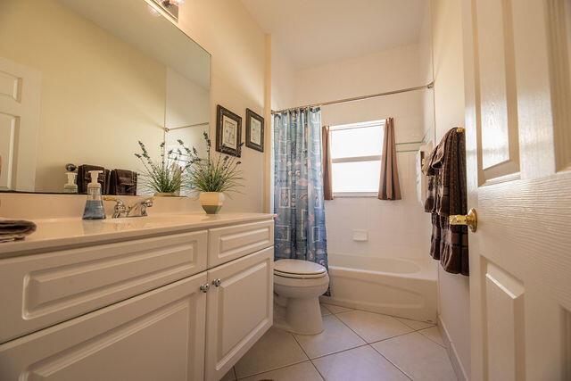 full bathroom featuring vanity, toilet, tile patterned flooring, and shower / bath combo