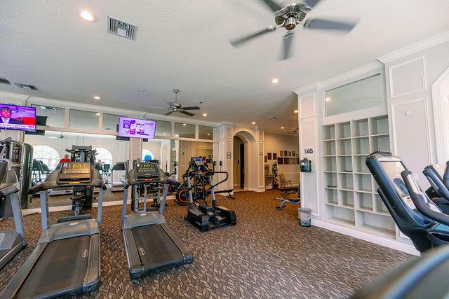 exercise room with crown molding, a textured ceiling, and ceiling fan