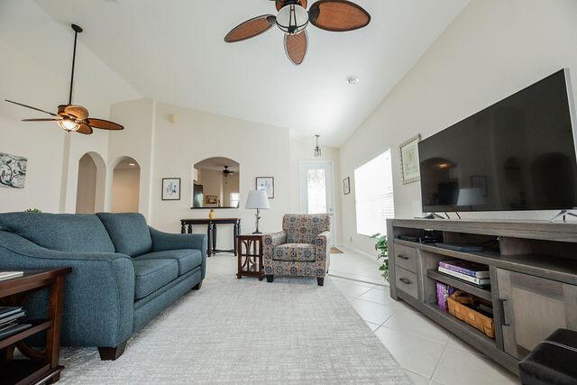 living room featuring ceiling fan, high vaulted ceiling, and light tile patterned floors