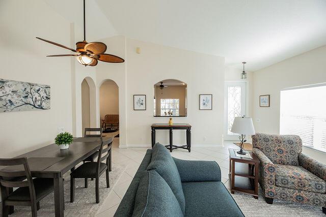 tiled living room featuring vaulted ceiling and ceiling fan