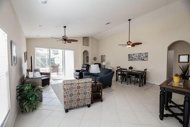 living room featuring light tile patterned flooring, vaulted ceiling, and ceiling fan