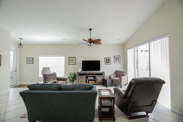 living room with vaulted ceiling, light tile patterned floors, and ceiling fan