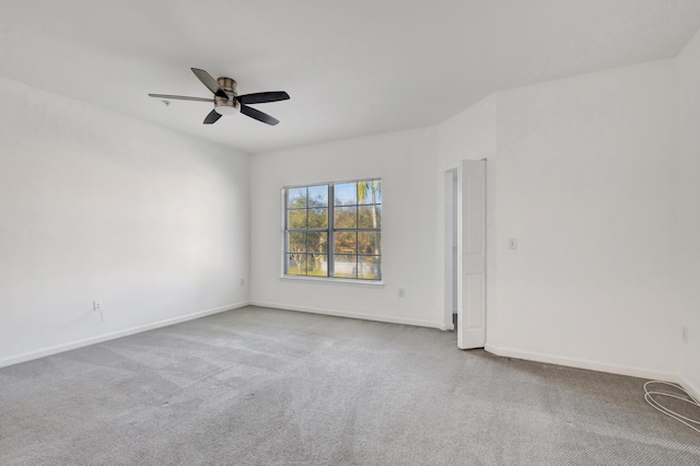 carpeted empty room featuring baseboards and ceiling fan