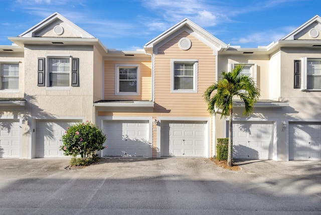 multi unit property with a garage and stucco siding