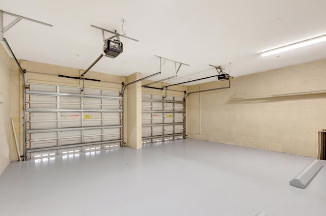 garage featuring a garage door opener and concrete block wall