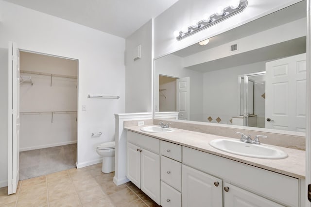 bathroom with a stall shower, visible vents, a sink, and toilet