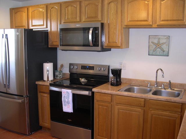 kitchen featuring sink, light tile patterned flooring, and appliances with stainless steel finishes