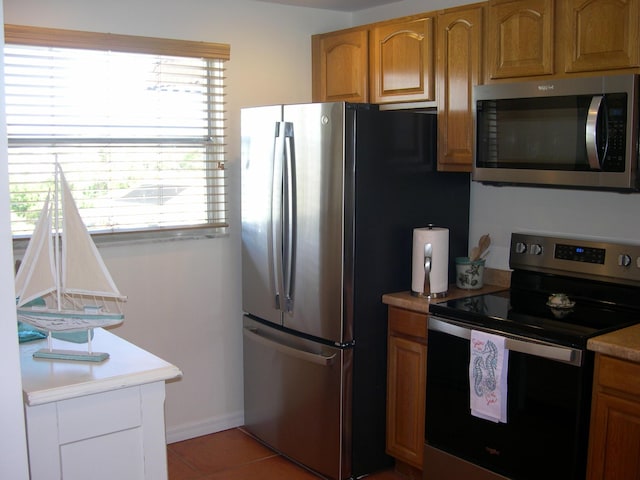 kitchen with light tile patterned floors and appliances with stainless steel finishes