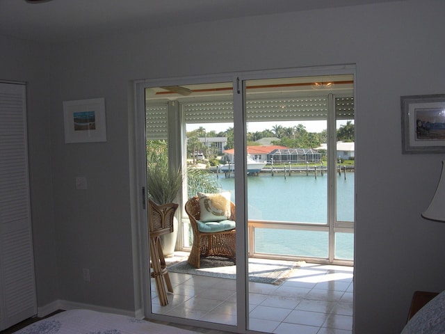 doorway to outside featuring a water view, plenty of natural light, and light tile patterned floors