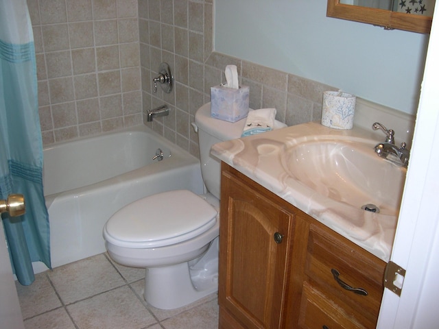 full bathroom featuring toilet, shower / tub combo, tile walls, vanity, and tile patterned flooring