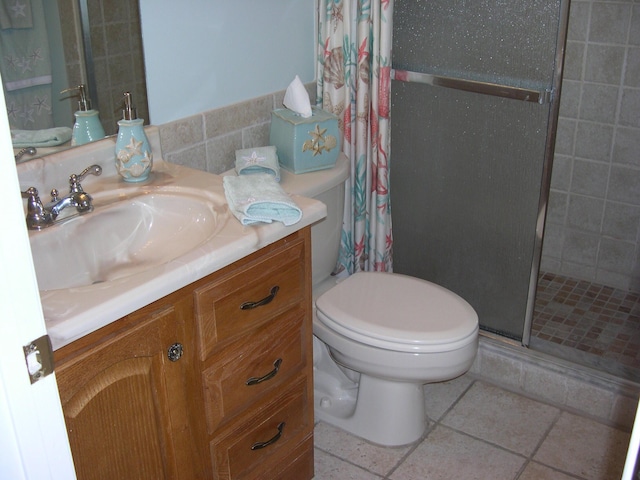 bathroom featuring tile patterned flooring, tile walls, vanity, a shower with curtain, and toilet