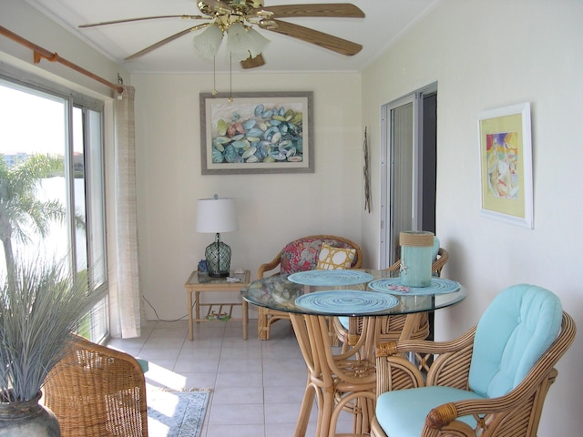 tiled dining area featuring crown molding and ceiling fan