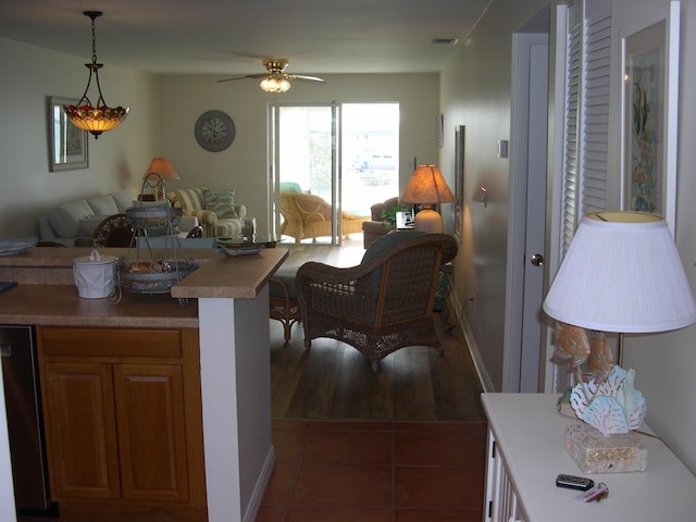 interior space with hanging light fixtures, dishwasher, dark tile patterned floors, and ceiling fan