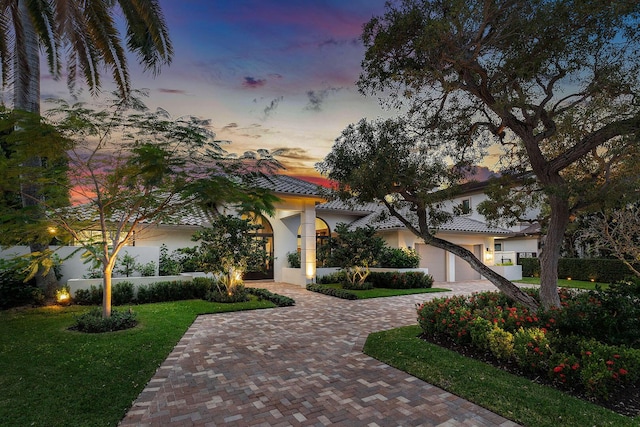 view of front of home featuring a garage and a yard