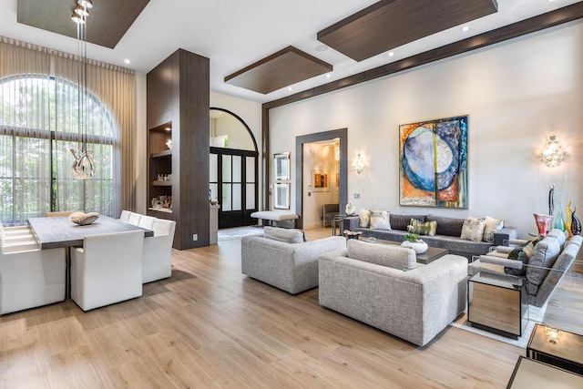 living room with light hardwood / wood-style floors and a high ceiling