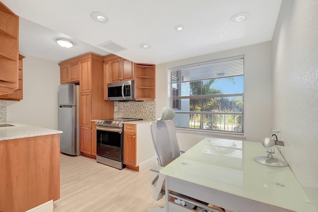 kitchen featuring appliances with stainless steel finishes, decorative backsplash, and light hardwood / wood-style flooring