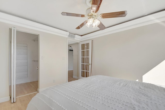 bedroom with crown molding, ceiling fan, and light hardwood / wood-style flooring