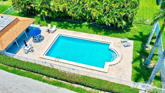 view of pool with a lawn and a patio