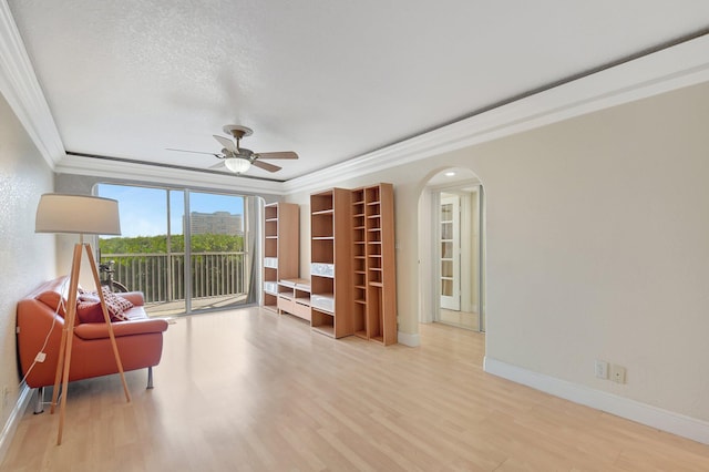 living area with ceiling fan, ornamental molding, light hardwood / wood-style floors, and a textured ceiling