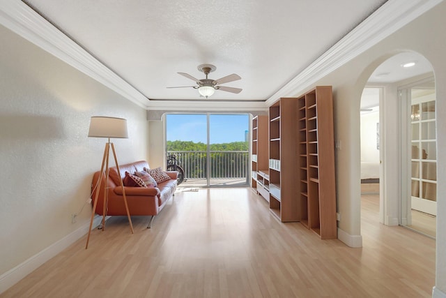 sitting room featuring a textured ceiling, ornamental molding, light hardwood / wood-style floors, and ceiling fan