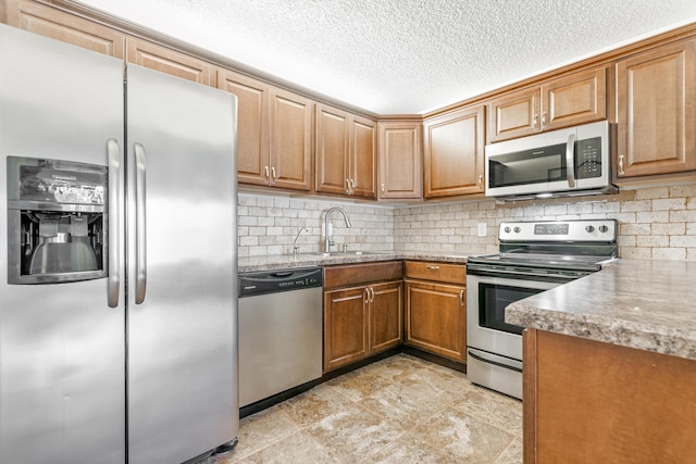 kitchen with appliances with stainless steel finishes, sink, a textured ceiling, and backsplash