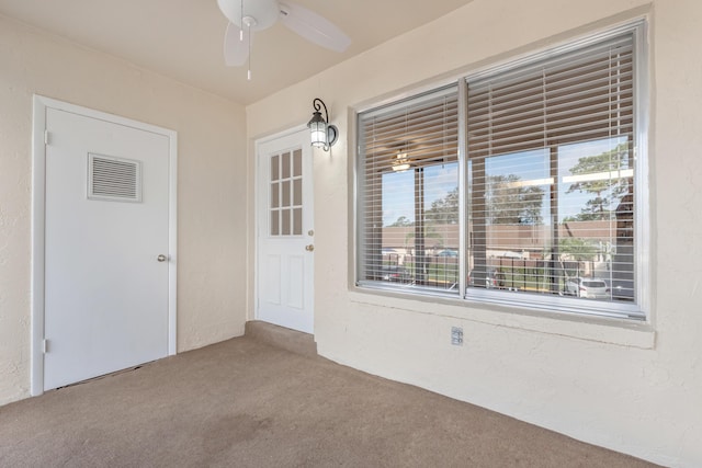 carpeted empty room featuring ceiling fan