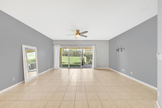 tiled empty room featuring ceiling fan