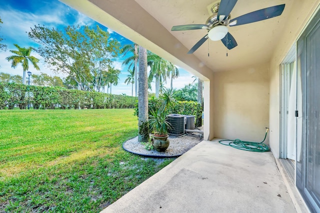 view of yard featuring central AC unit, ceiling fan, and a patio area