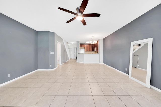 unfurnished living room featuring ceiling fan with notable chandelier and light tile patterned floors