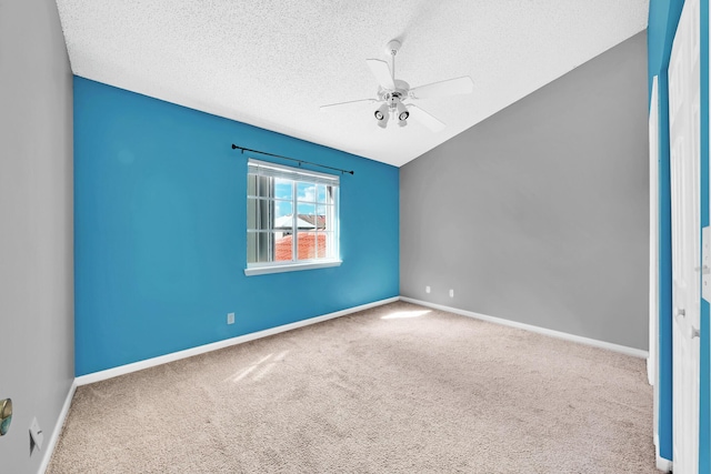 unfurnished room with ceiling fan, lofted ceiling, carpet floors, and a textured ceiling