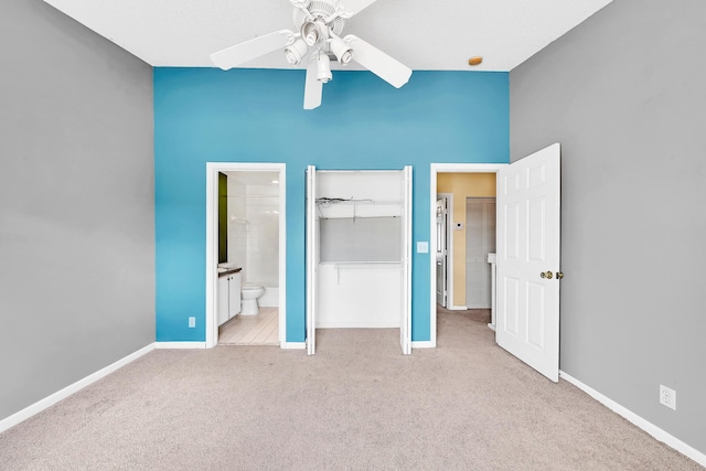 unfurnished bedroom with connected bathroom, light colored carpet, ceiling fan, and a closet