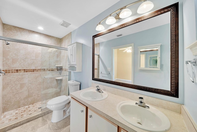 bathroom featuring vanity, a shower with shower door, and toilet