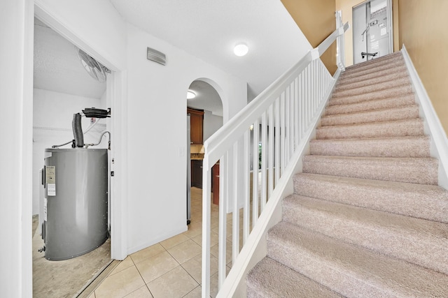 staircase with tile patterned flooring and electric water heater