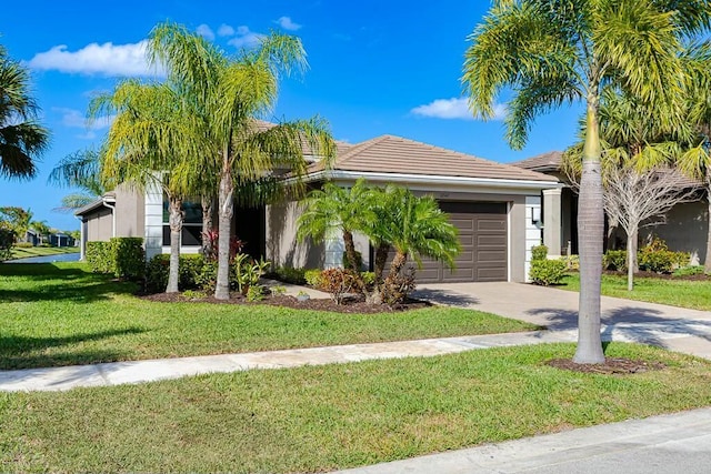 view of front of property with a front lawn, a tiled roof, stucco siding, a garage, and driveway