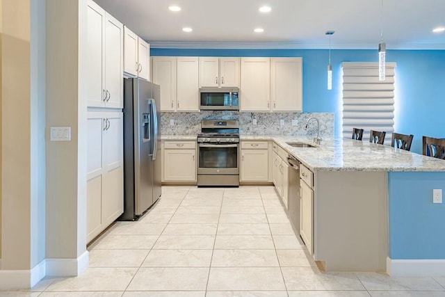 kitchen with light tile patterned floors, a peninsula, a sink, decorative backsplash, and appliances with stainless steel finishes