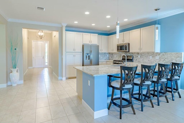 kitchen featuring visible vents, appliances with stainless steel finishes, a peninsula, and ornamental molding