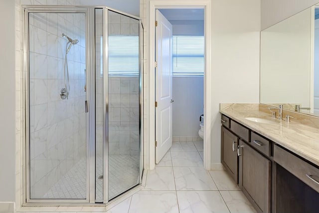 full bathroom with vanity, baseboards, a shower stall, toilet, and marble finish floor