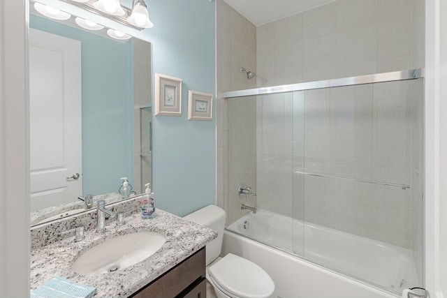 bathroom featuring combined bath / shower with glass door, toilet, and vanity