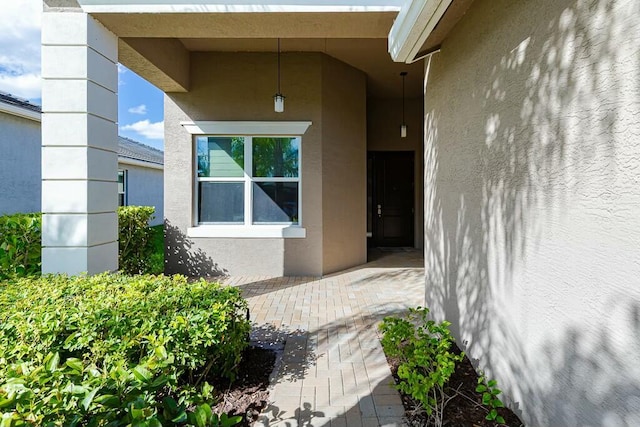 doorway to property featuring stucco siding