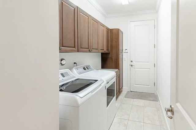 washroom with crown molding, baseboards, washer and clothes dryer, light tile patterned floors, and cabinet space