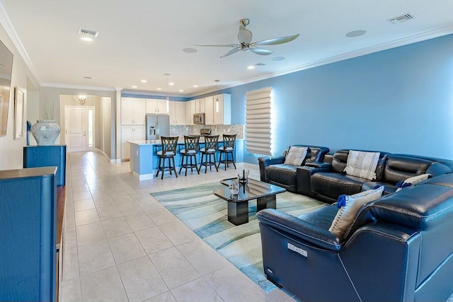 living area with crown molding, light tile patterned flooring, visible vents, and ceiling fan